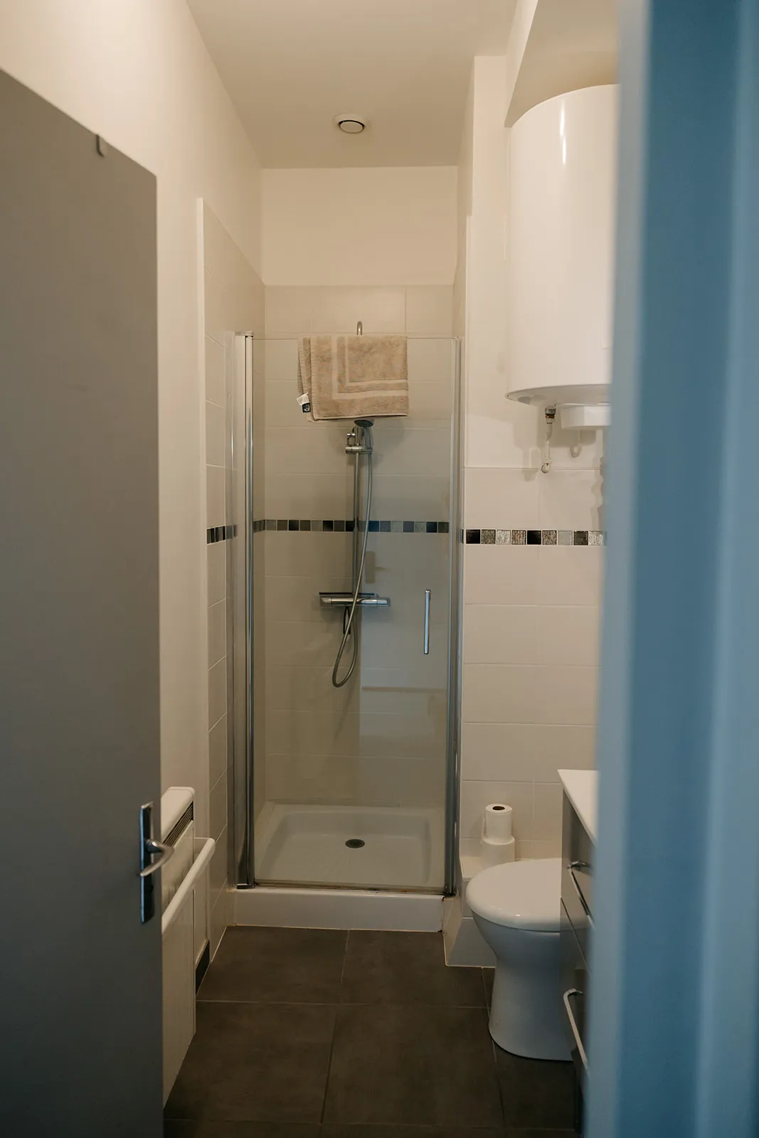 Salle de bain carrelée du studio avec vasque et rangements